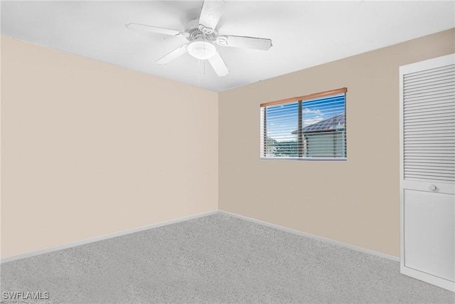 carpeted spare room with ceiling fan