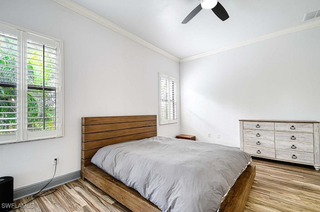 bedroom featuring hardwood / wood-style flooring, ceiling fan, and ornamental molding