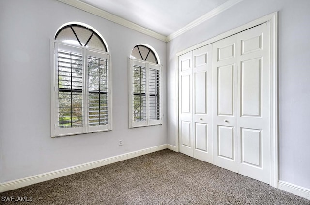 unfurnished bedroom with carpet floors, a closet, and crown molding