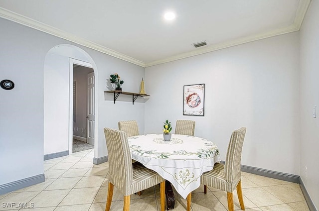 dining space with ornamental molding and light tile patterned floors