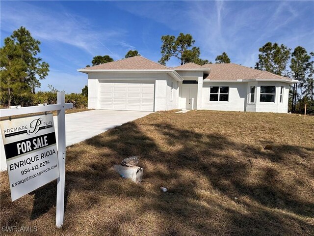 ranch-style home with a garage and a front lawn