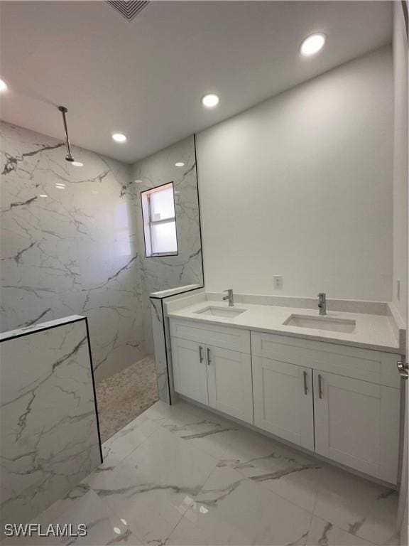 bathroom with a tile shower and vanity