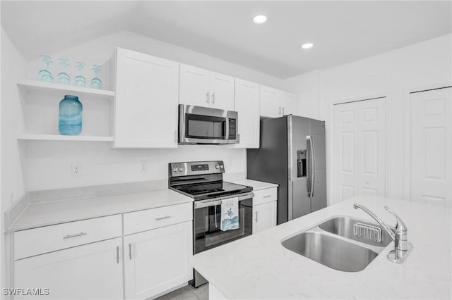 kitchen featuring light stone countertops, sink, white cabinetry, and stainless steel appliances