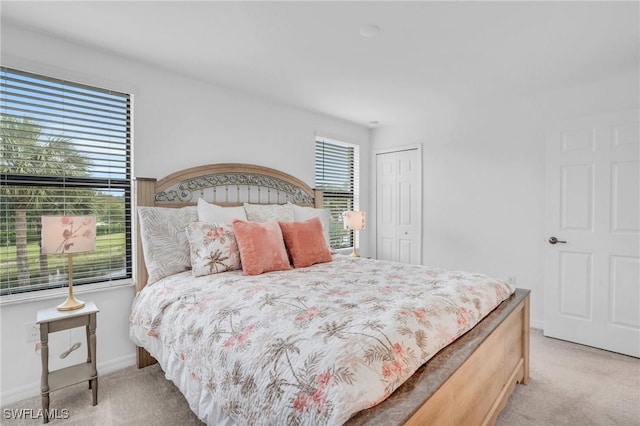 bedroom featuring light carpet and a closet