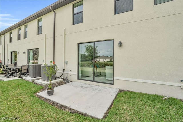 rear view of property featuring a yard, a patio, and cooling unit