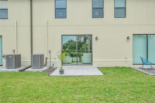 rear view of house featuring a patio area, a yard, and central AC