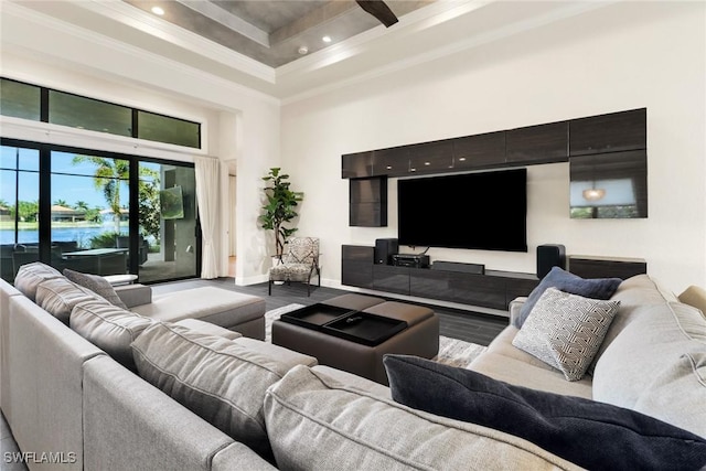 living room featuring hardwood / wood-style flooring, a high ceiling, and ornamental molding