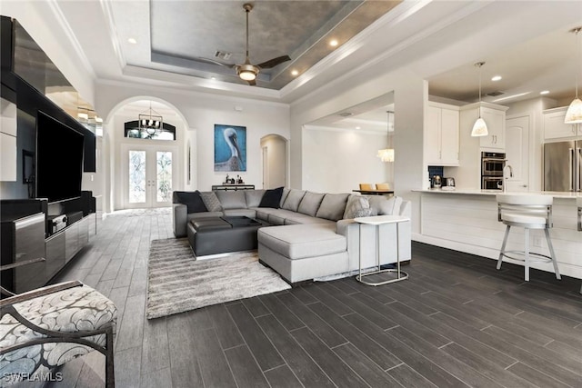 living room featuring ornamental molding, french doors, and a raised ceiling