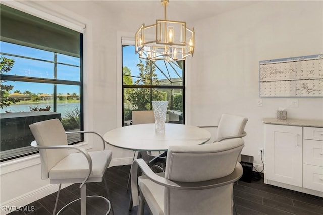 dining area with a chandelier, a water view, and a healthy amount of sunlight