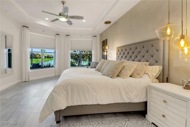 bedroom featuring ceiling fan and a tray ceiling