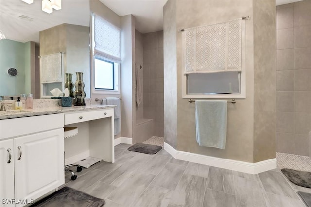 bathroom featuring vanity and tiled shower