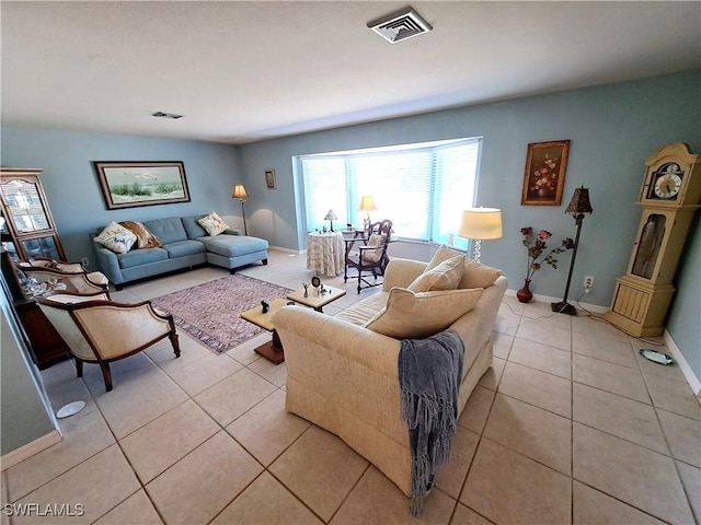 living room with visible vents, baseboards, and light tile patterned floors