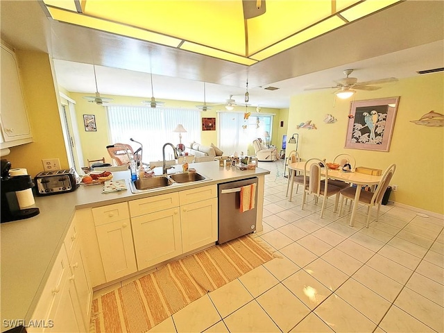 kitchen featuring dishwasher, open floor plan, a peninsula, a sink, and light tile patterned flooring