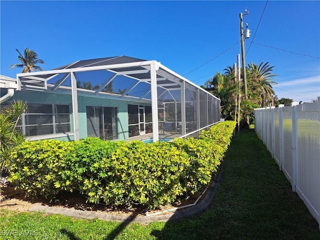 view of yard featuring fence and a lanai