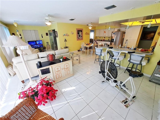 interior space featuring light tile patterned floors, baseboards, visible vents, and a ceiling fan