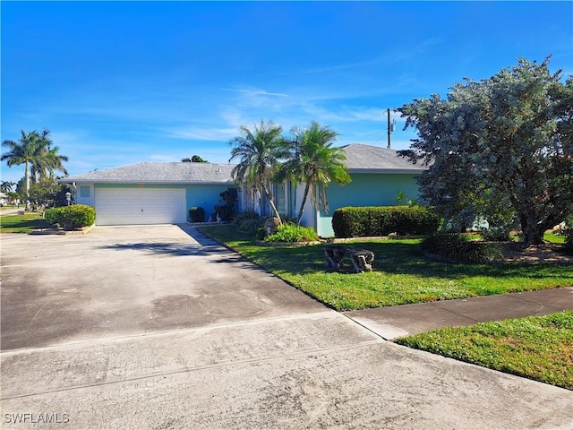 single story home with a garage, concrete driveway, a front lawn, and stucco siding