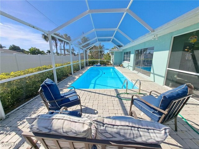 view of swimming pool featuring a lanai and a patio area