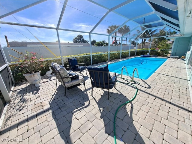 view of swimming pool with glass enclosure and a patio area