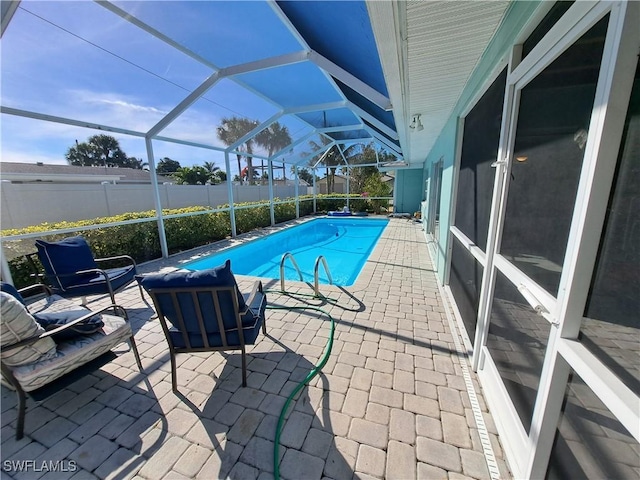 view of swimming pool featuring a lanai and a patio area