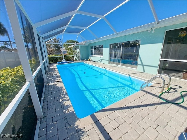 view of swimming pool with a patio area and a lanai