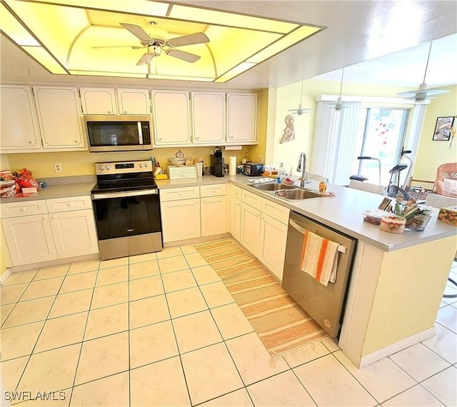 1727 Lakeview Blvd, North Fort Myers, FL 33903 - kitchen with stainless steel appliances, a sink, a peninsula, light tile patterned floors, and light countertops