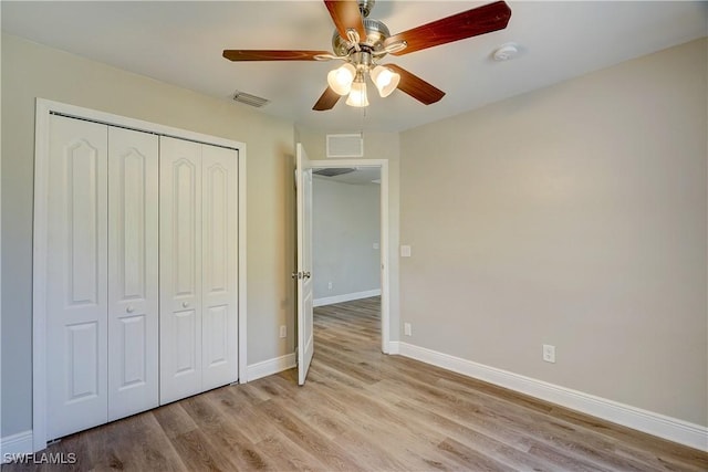 unfurnished bedroom with light wood-type flooring, a closet, and ceiling fan