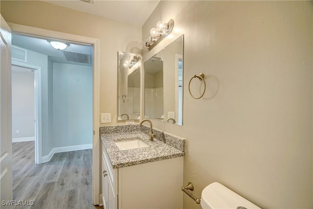 bathroom with vanity, wood-type flooring, and toilet