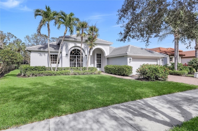 mediterranean / spanish-style home with a front lawn and a garage