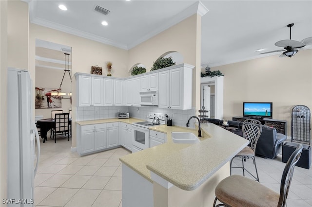 kitchen featuring sink, white cabinets, white appliances, and kitchen peninsula