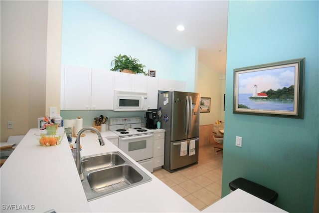 kitchen with light tile patterned floors, white appliances, white cabinetry, and sink