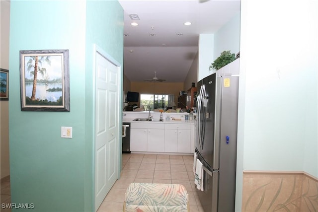 kitchen featuring ceiling fan, sink, stainless steel appliances, light tile patterned floors, and white cabinets