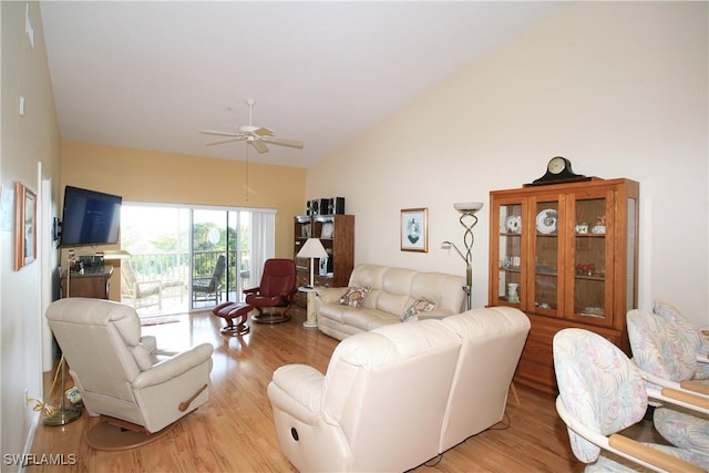 living room with ceiling fan, vaulted ceiling, and light wood-type flooring