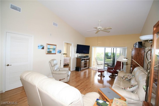 living room featuring light hardwood / wood-style floors, high vaulted ceiling, and ceiling fan