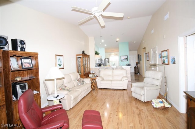 living room featuring high vaulted ceiling, light hardwood / wood-style flooring, and ceiling fan