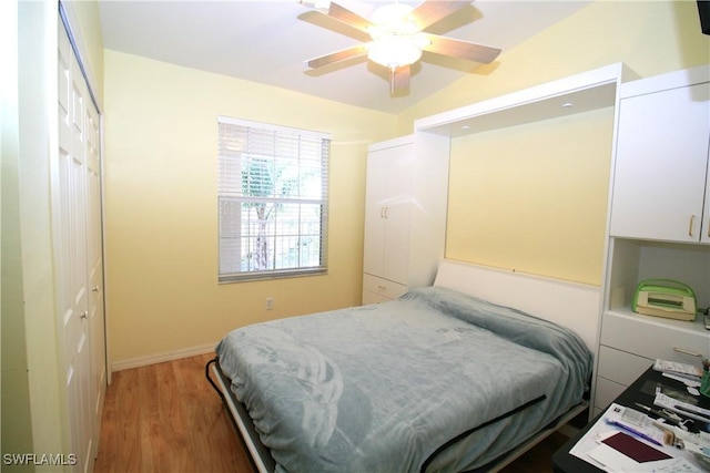 bedroom featuring ceiling fan, vaulted ceiling, dark hardwood / wood-style flooring, and a closet