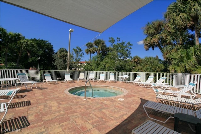 view of swimming pool featuring a hot tub and a patio area