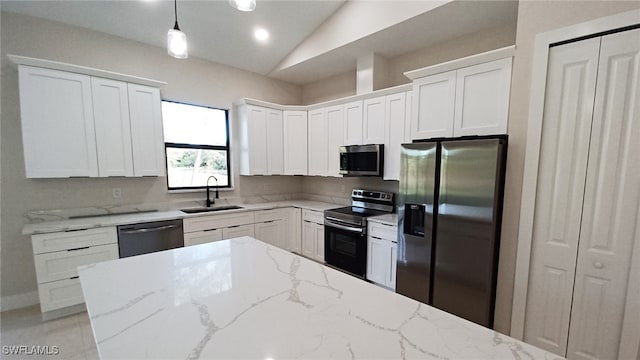 kitchen with a sink, white cabinets, decorative light fixtures, and stainless steel appliances