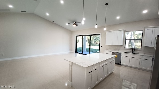 kitchen with light stone countertops, a kitchen island, a sink, vaulted ceiling, and dishwasher