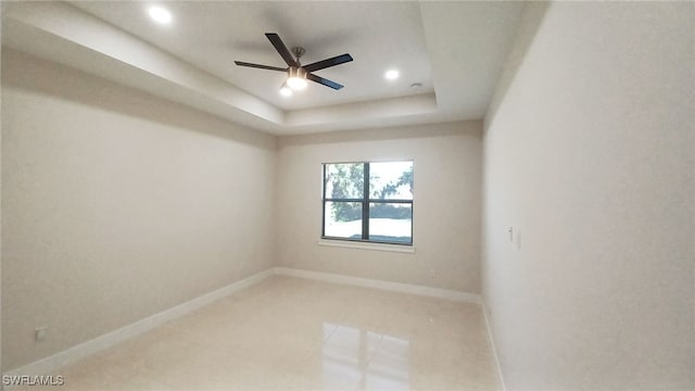 empty room with recessed lighting, baseboards, a raised ceiling, and ceiling fan