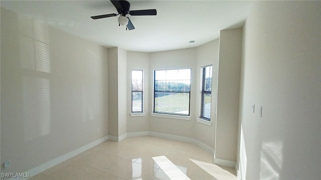 tiled spare room featuring ceiling fan