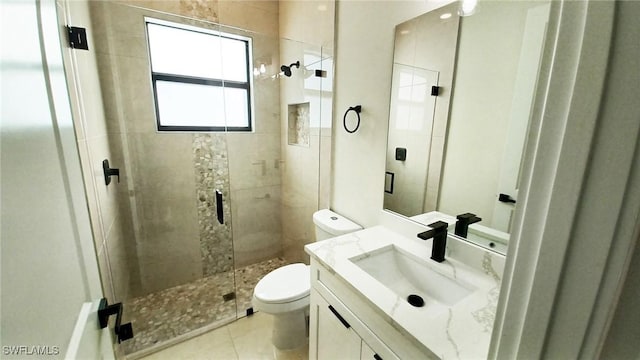 bathroom featuring vanity, tile patterned floors, toilet, and a stall shower