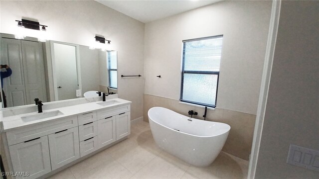 bathroom featuring tile patterned floors, vanity, and a washtub