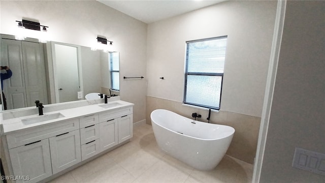 bathroom featuring visible vents, a sink, tile patterned flooring, double vanity, and a freestanding bath