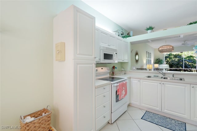 kitchen with white appliances, sink, light tile patterned floors, white cabinets, and hanging light fixtures