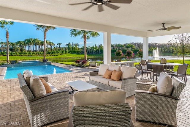 view of swimming pool featuring a patio area, pool water feature, a water view, and an outdoor living space