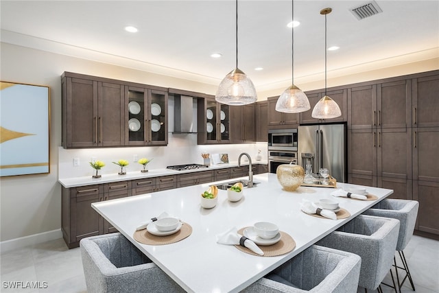 kitchen featuring an island with sink, stainless steel appliances, a breakfast bar area, and sink