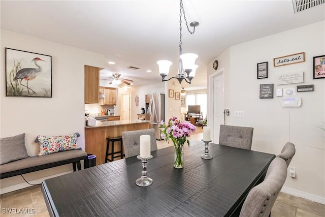 dining area with light tile patterned floors and ceiling fan with notable chandelier