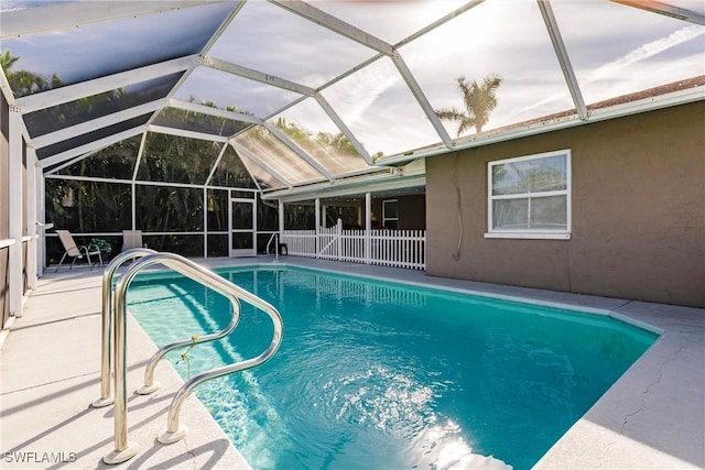 view of pool with glass enclosure and a patio