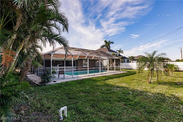 view of pool featuring glass enclosure and a yard