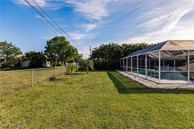 view of yard featuring glass enclosure and a fenced in pool